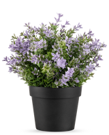 La pianta artificiale Buxus viola UV 22 cm ha un vaso da fiori nero con una rigogliosa pianta artificiale con piccoli fiori viola chiaro e foglie verdi su uno sfondo bianco.
