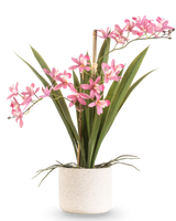 La pianta artificiale Mini Cymbidium Real Touch 45 cm rosa ha lunghe foglie verdi e diversi steli di fiori rosa, disposti in un vaso semplice con struttura bianca e su uno sfondo semplice.