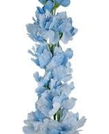 Il Delphinium Real Touch Blu Artificiale 90 cm è una ghirlanda verticale di morbidi fiori artificiali di colore azzurro con volant su stelo verde, su sfondo bianco.
