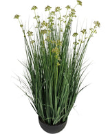 Il vaso per erba artificiale con fiori di porro e cipolla da 100 cm ignifugo ha foglie verdi lunghe e sottili simili a erba e piccoli grappoli di fiori giallo-verdi in un vaso nero rotondo, su uno sfondo bianco.
