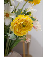Un primo piano del Ranuncolo Artificiale Real Touch Yellow da 60 cm, un ranuncolo artificiale giallo vivace con petali stratificati, adatto in un vaso da interno accanto a fiori bianchi e rosa chiaro.