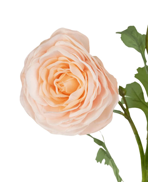 Un primo piano della rosa artificiale "Emine" Real Touch Peach 62 cm, con petali stratificati color pesca e foglie verdi su sfondo bianco.