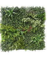La siepe artificiale Prestige 100x100 cm UV è un pannello quadrato di fogliame verde artificiale con piante miste a foglia, felci, texture varie e sfumature di verde, oltre a grappoli di piccoli fiori bianchi e rossi. Lo sfondo è bianco.