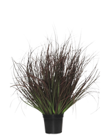 Il prato per piante in erba artificiale ignifugo da 50 cm viene fornito in un vaso di plastica nera, con erba ornamentale appuntita con foglie lunghe e sottili, viola scuro e verdi - perfette per la decorazione d'interni - su uno sfondo bianco.