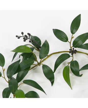 Een Kunst Smilax Slinger van 180 cm met lange, smalle groene bladeren en kleine trossen donkere, ronde bessen, afgebeeld tegen een witte achtergrond.