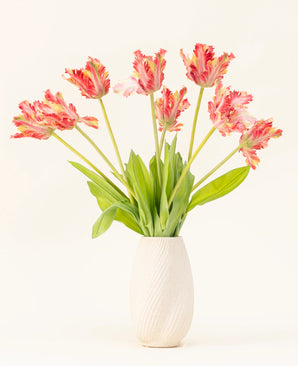 Een vaas met witte structuur toont het Zijden kunstbloemen boeket Franse Parkiet Tulp rood/geel, met levensechte rode en gele tulpen met groene bladeren tegen een effen lichte achtergrond.
