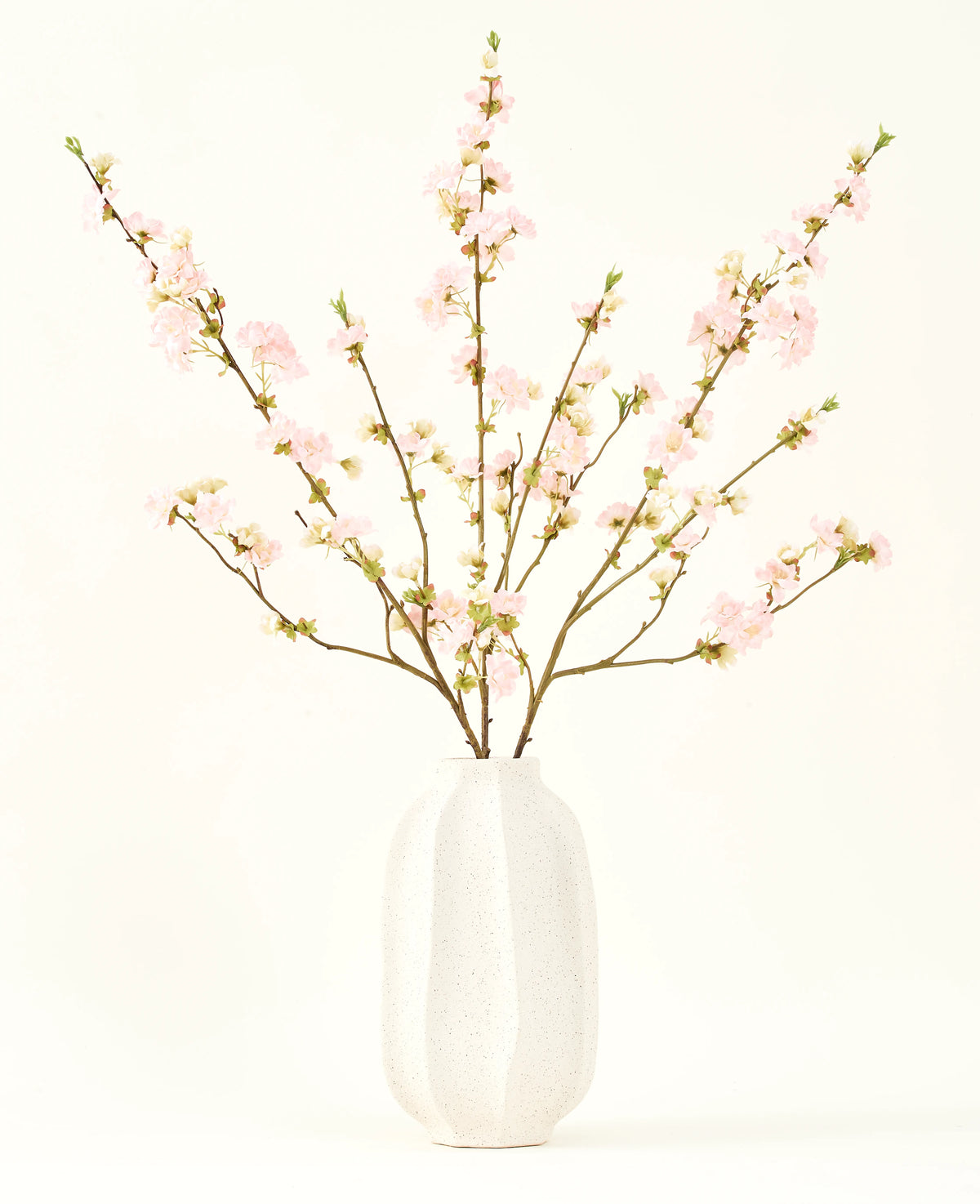 Il bouquet di fiori artificiali in seta Fiore di ciliegio rosa chiaro 94 cm presenta delicati fiori di ciliegio artificiali rosa in un vaso di ceramica bianca, che aggiunge eleganza su uno sfondo chiaro e semplice.