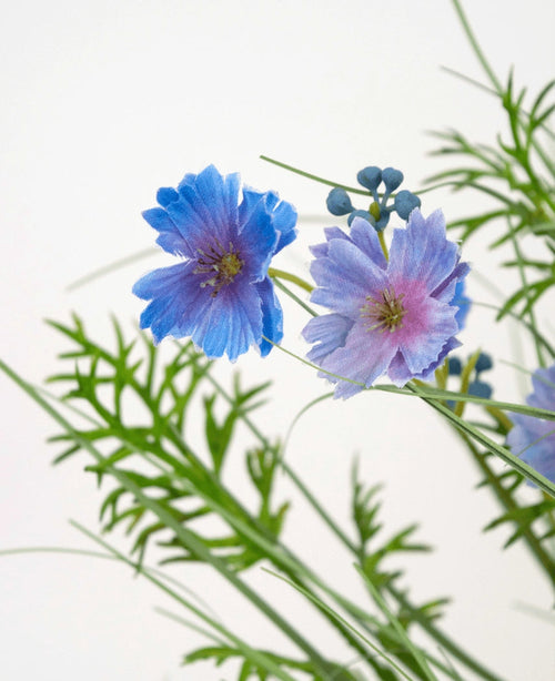 Il vaso di erba artificiale a cipolla viola Gesang Flower (56 cm, ignifugo) ha delicati fiori viola con foglie verdi simili a felci e piccoli boccioli rotondi, su un semplice sfondo bianco.