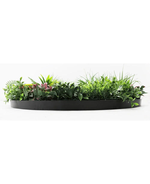 Una siepe artificiale su telaio nero Ø100 cm, dal rigoglioso fogliame verde e viola, risalta su uno sfondo bianco.