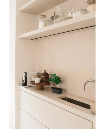 Minimalistisch aanrecht met een kleine gootsteen, decoratieve potten, een koffiezetapparaat en bakken op zwevende planken. In het neutrale wit-beige kleurenschema staat de Kunstplant Bonsai Ficus 30 cm als accentpotplant.