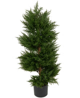 De Kunstplant Conifeer UV 90cm is een hoge groene kunstdennenboom met dicht gebladerte in een eenvoudige zwarte pot, tegen een effen witte achtergrond.