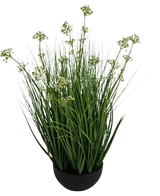 Il vaso per erba artificiale con fiori di porro e cipolla da 60 cm ignifugo ha foglie verdi alte e sottili simili a erba con piccoli grappoli di fiori bianchi in un vaso nero, su uno sfondo bianco.