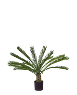 De Kunstplant Cycus Palm Deluxe 95 cm heeft overhangende, vederachtige groene bladeren en een dikke, gestructureerde stam tegen een effen witte achtergrond.
