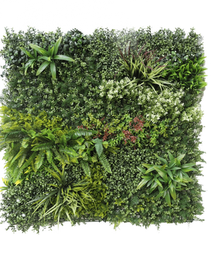 La siepe artificiale Prestige 100x100 cm UV è un pannello quadrato di fogliame verde artificiale con piante miste a foglia, felci, varie texture e sfumature di verde, oltre a grappoli di piccoli fiori bianchi e rossi. Lo sfondo è bianco.